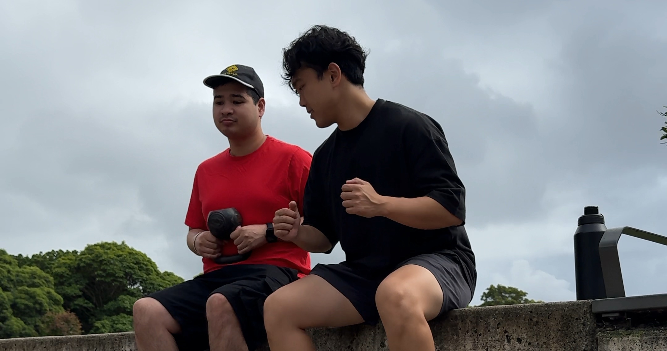 Drift Health exercise physiologist guiding an NDIS participant through a seated exercise outdoors