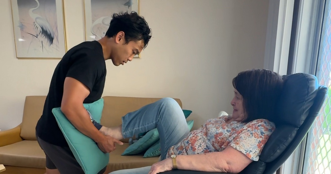 Drift Health physiotherapist supporting an older client’s leg during an in-home session
